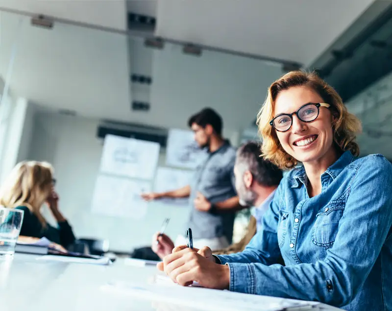 femme a lunettes souriante dans une réunion